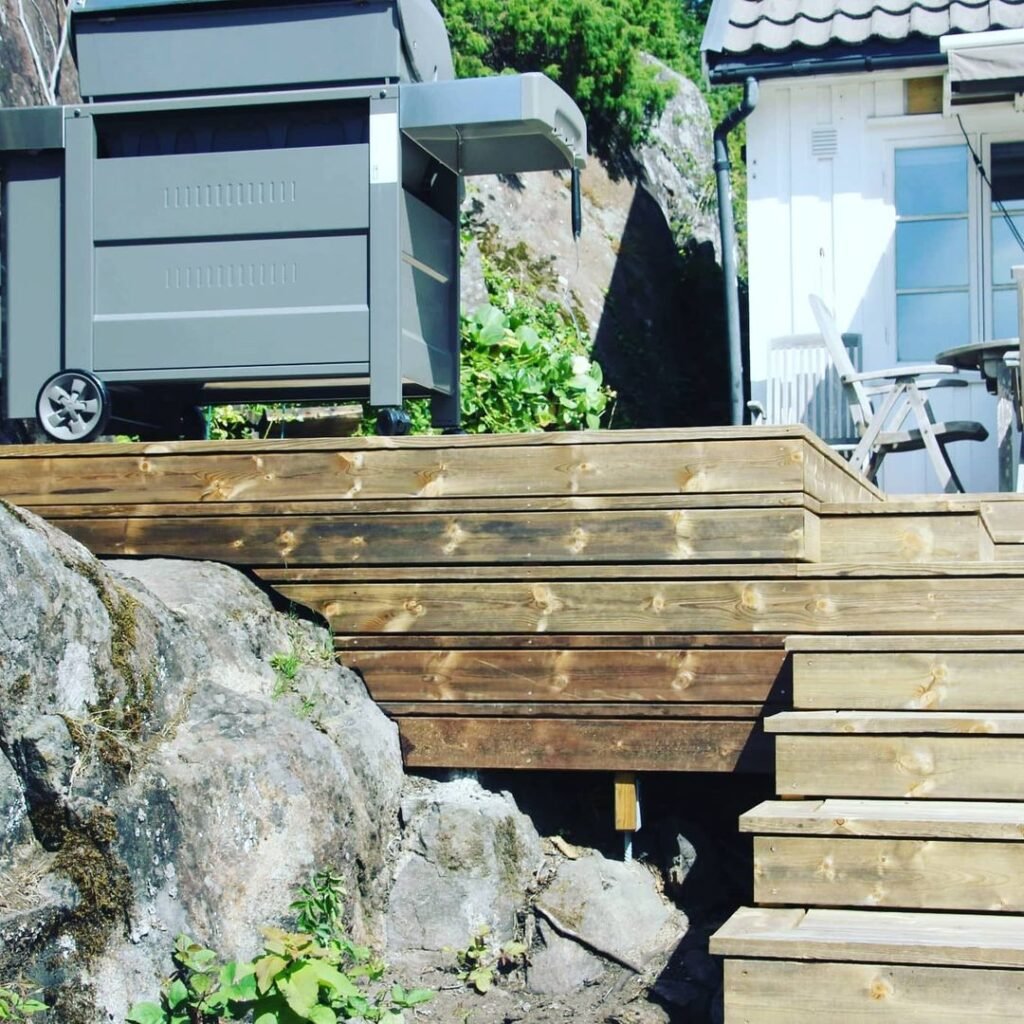 Træterrasse med grill og have møbler ved huset.