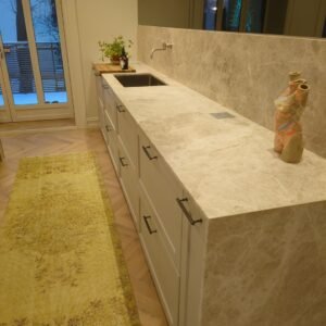 Moderne køkken med marmorbordplade og træskabsdøre.