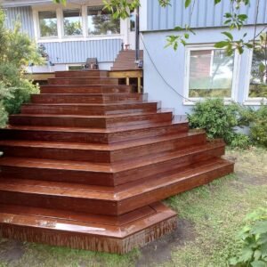 Moderne trætrappe foran blå hus