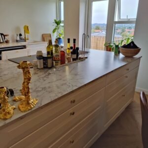 Moderne køkken med marmor bordplade og udsigt.