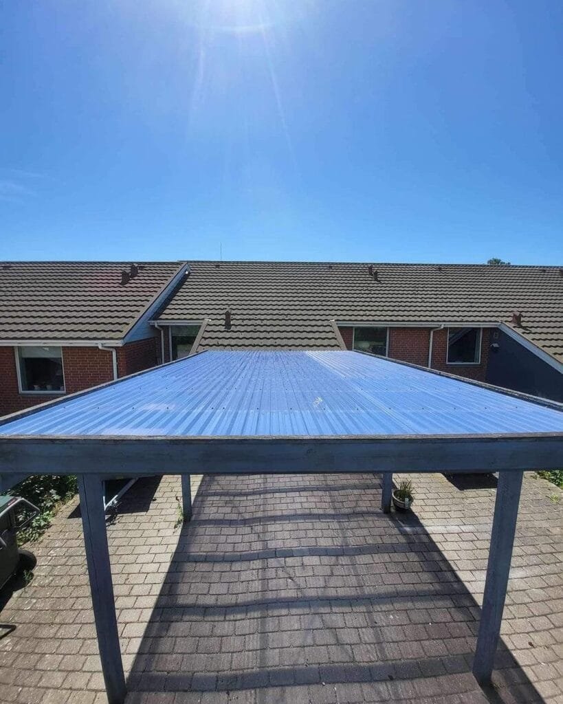 Blåt tag på en terrasse under klar himmel.