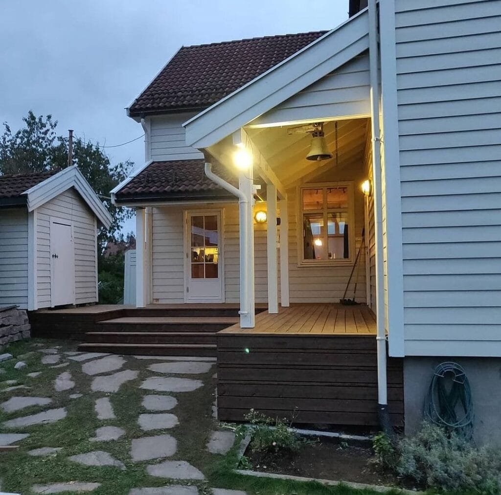 Moderne veranda i træ med udendørs belysning om aftenen.