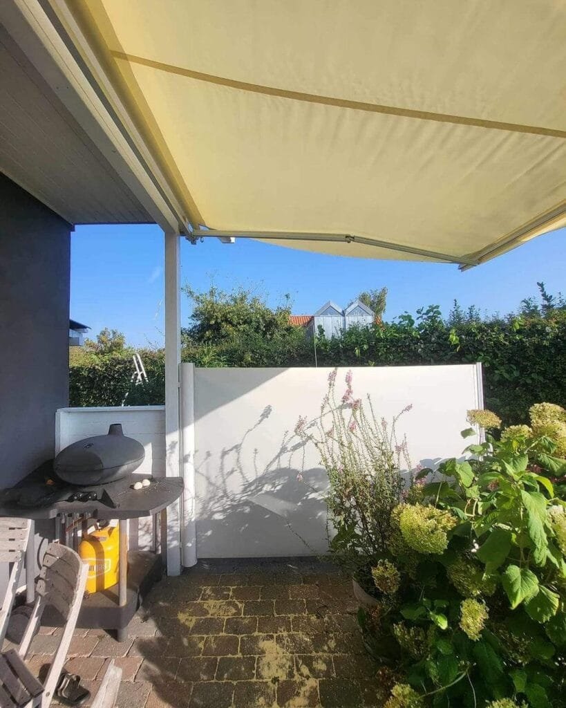 Terrasse med markise og grill i solskin