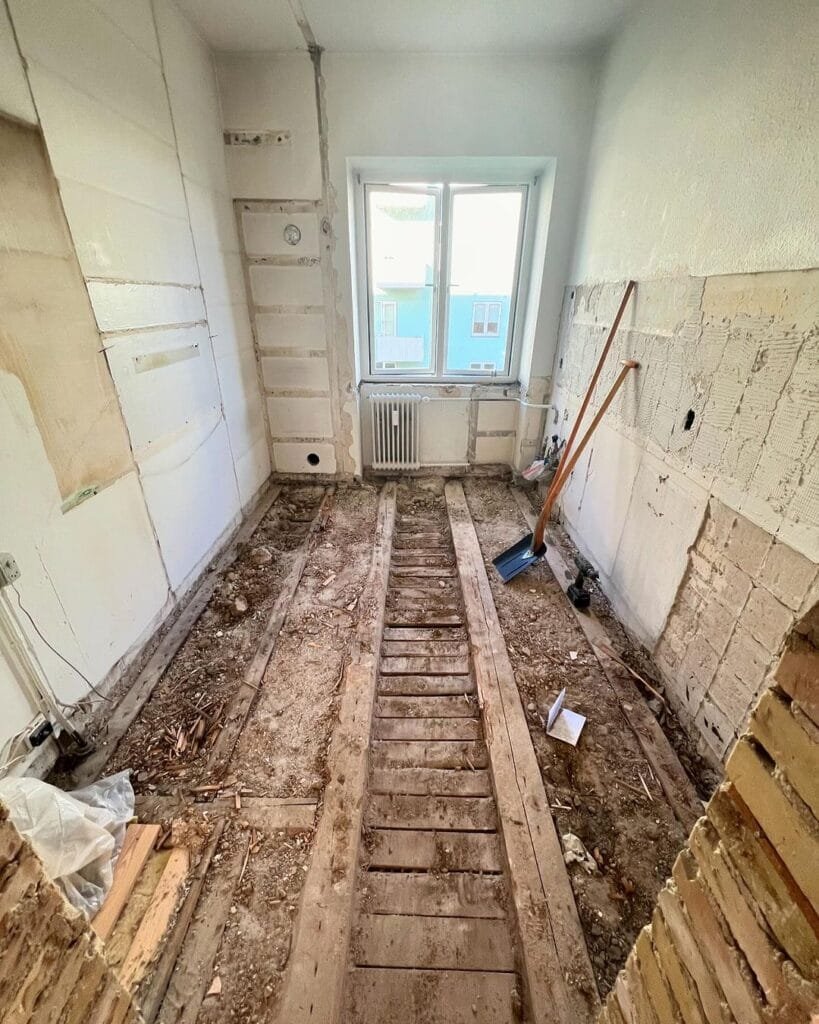 Renovering af værelse med fjernet gulv og vægbeklædning.