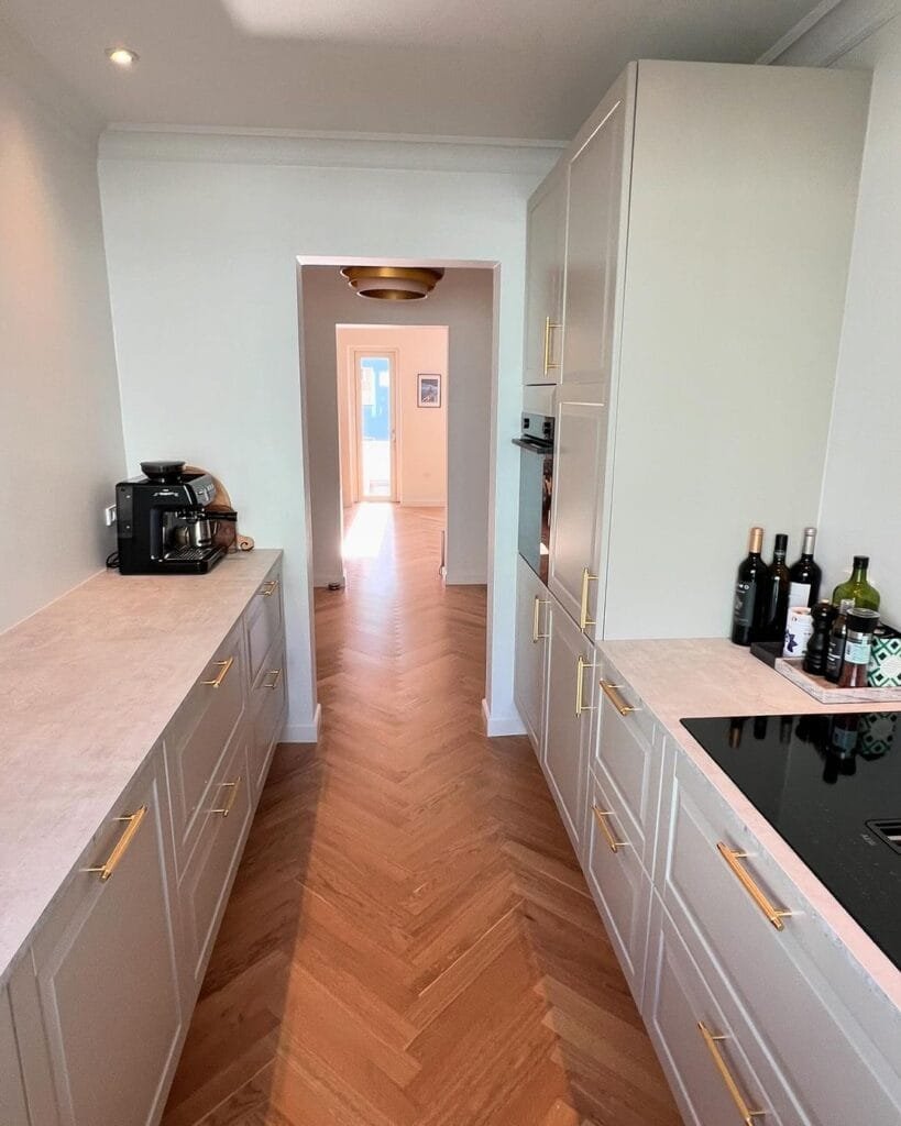 Moderne køkken med trægulv og hvide skabe